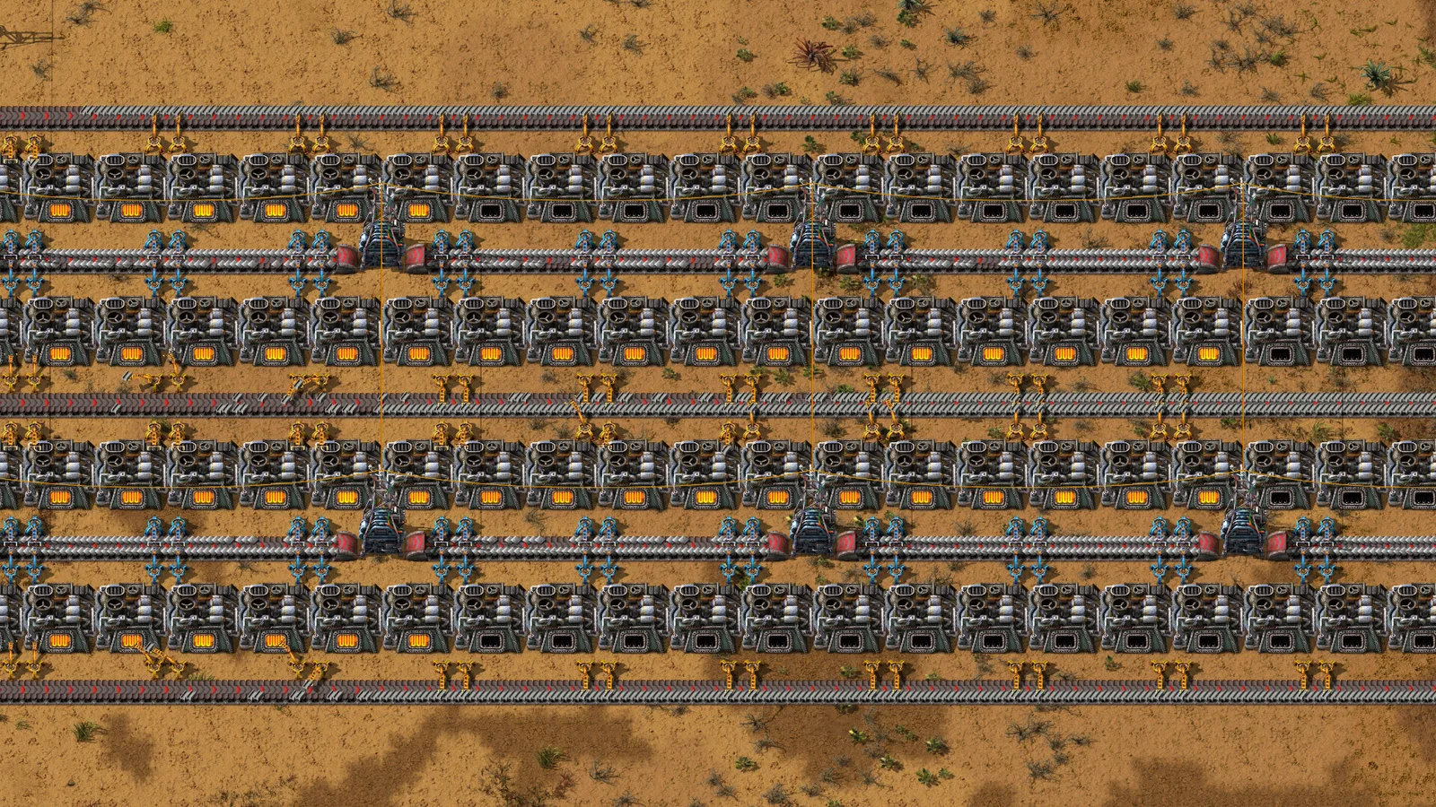 Rows of Factorio furnaces connected by belts carrying ore and metal plates