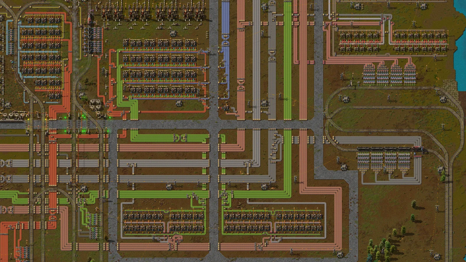 A zoomed-out Factorio factory organized around a central bus and production blocks