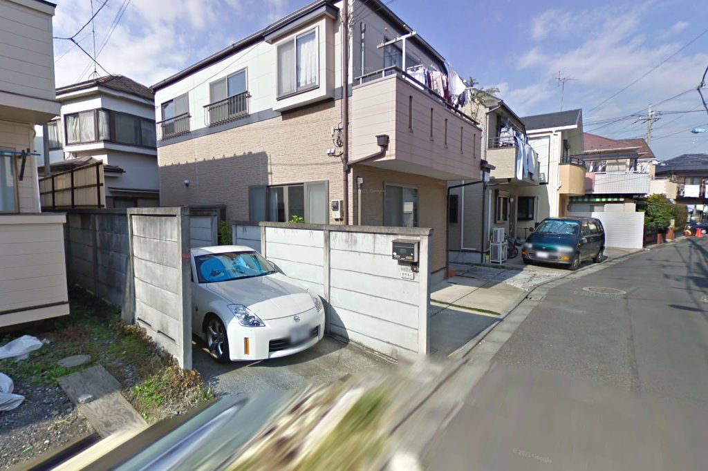 The same narrow Tokyo street in a 2009 Street View capture, with a white 350Z parked in the same spot